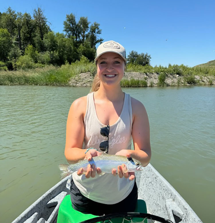 Drift boat fly fishing with guide on Bow river catching trout.
